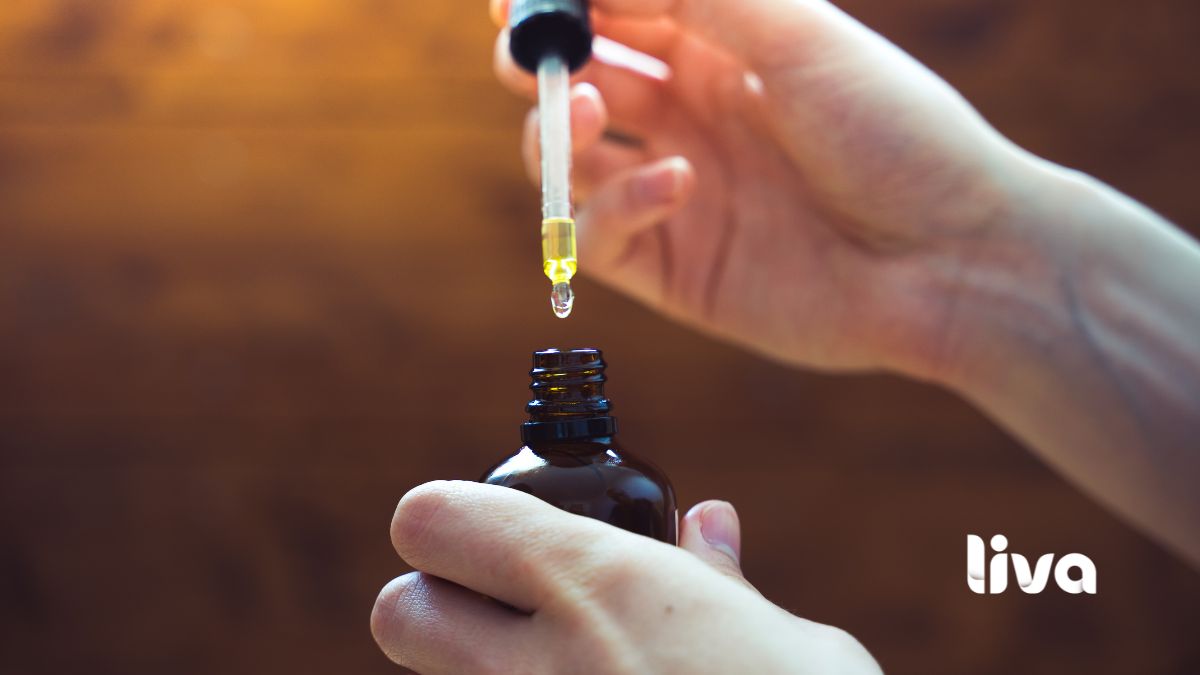 Pessoa utilizando conta-gotas com óleo de cannabis medicinal em frasco âmbar.